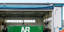 Grön Nordic Bulkers AB-container placerad framför en öppen industrilokal.